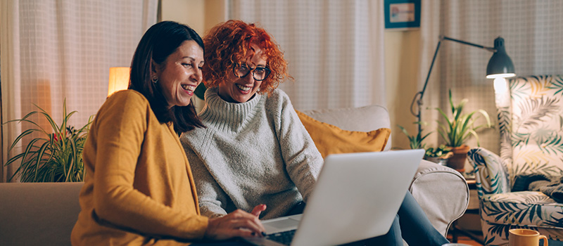 Two women using a laptop at home