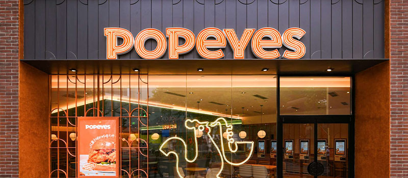 Inside Popeyes University: How the restaurant chain is building its future leaders Popeyes restaurant exterior storefront signage