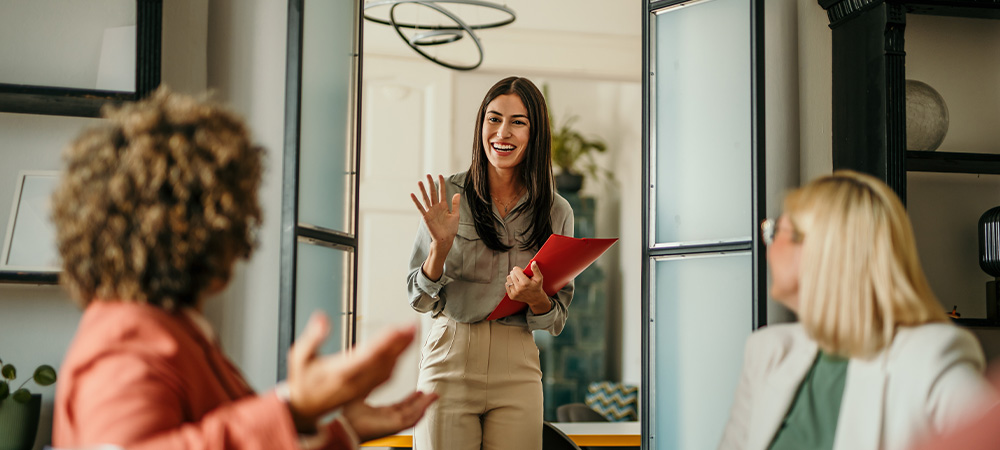 Smiling woman greeting coworkers meeting
