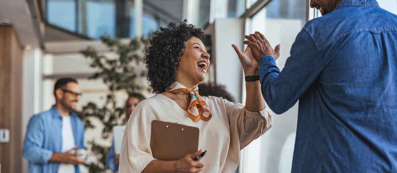 Building a magnetic employer brand in a crowded market Coworkers celebrating success with high-five