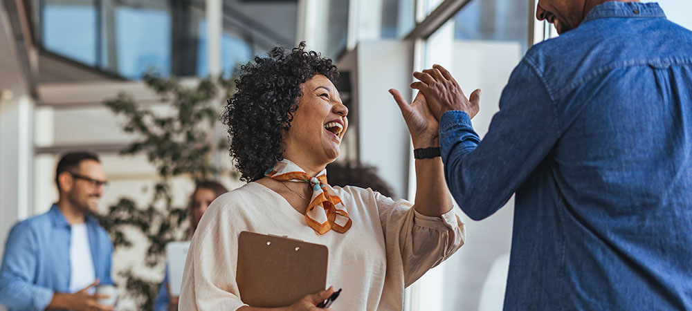 Coworkers celebrating success with high-five