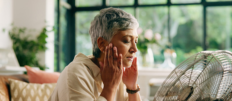 'Half the workforce' why HR can't afford to get menopause support wrong Woman cooling off with fan