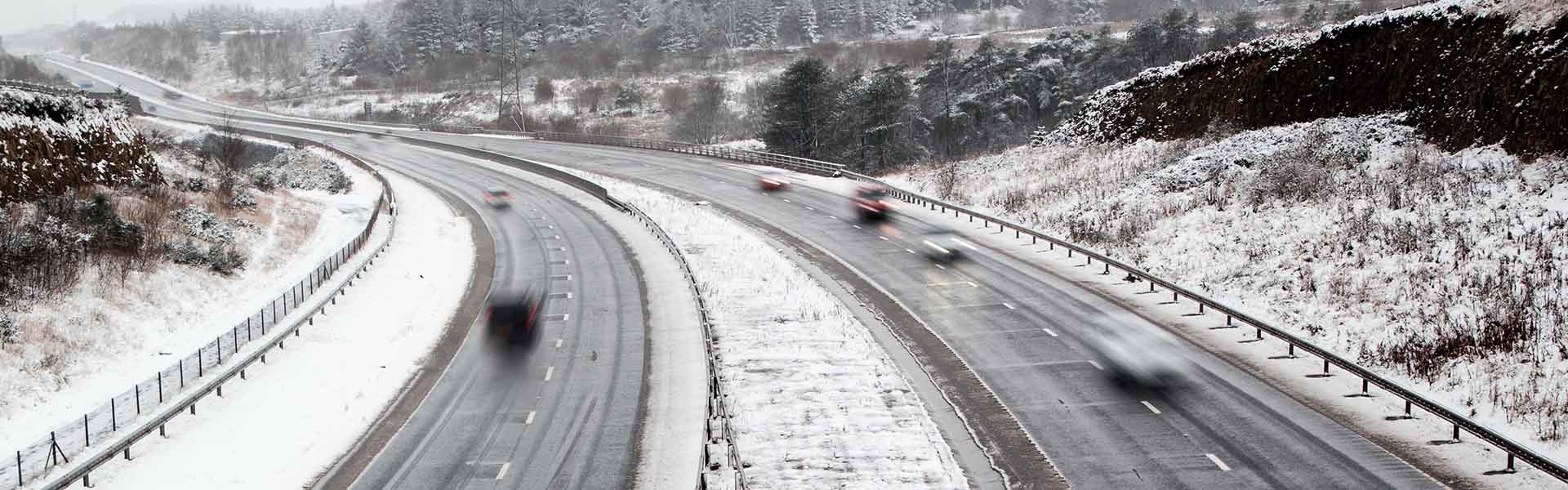 Snowy highway with moving cars