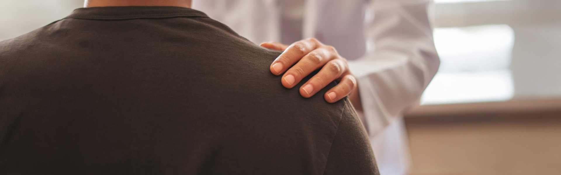 Doctor comforting patient shoulder