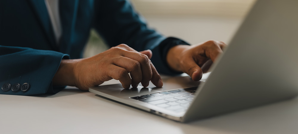 Business professional typing on laptop