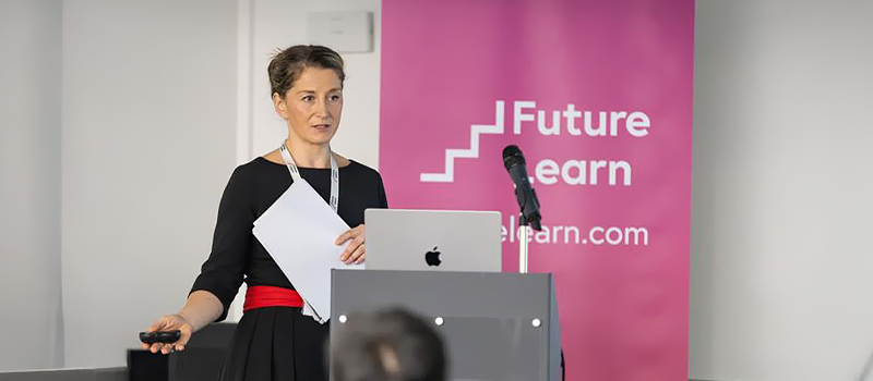 Upskilling is a saturated market and it's not working Woman presenting at conference