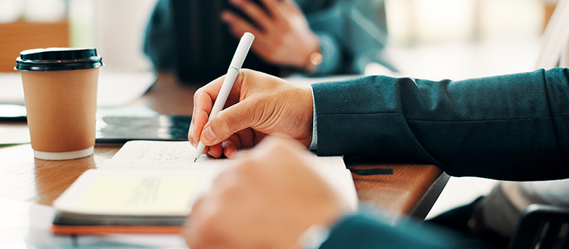 Boardroom meeting, writing notes on paper