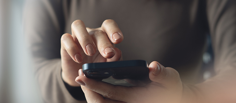 Hand typing on smartphone screen