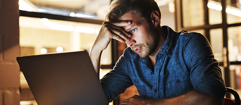 Stressed man working on laptop