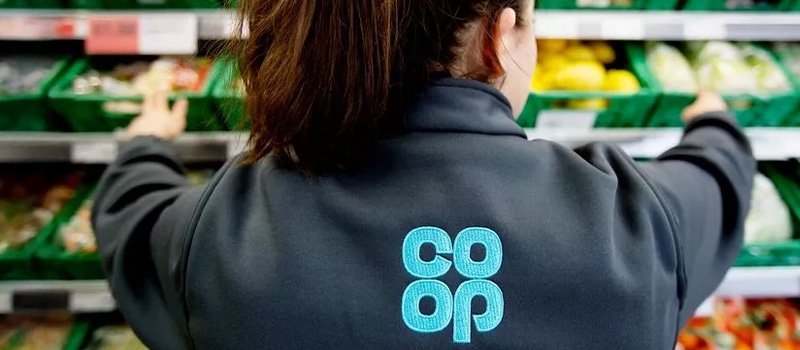 Co-op employee stocking produce