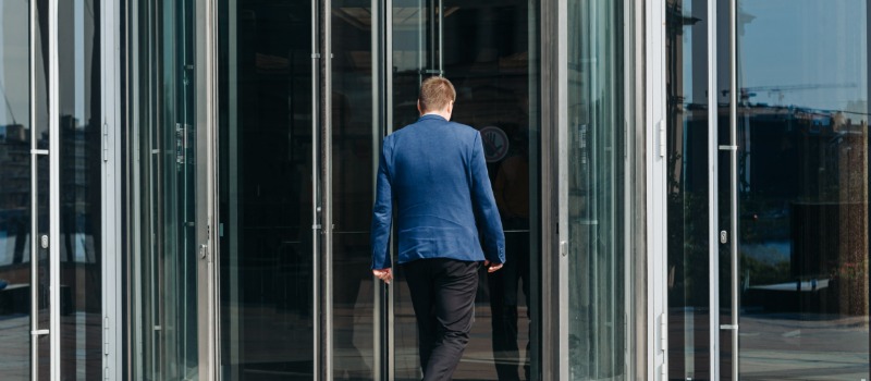 Man entering glass revolving door