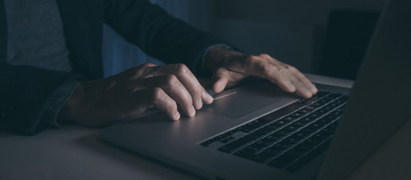 Hands typing on laptop keyboard