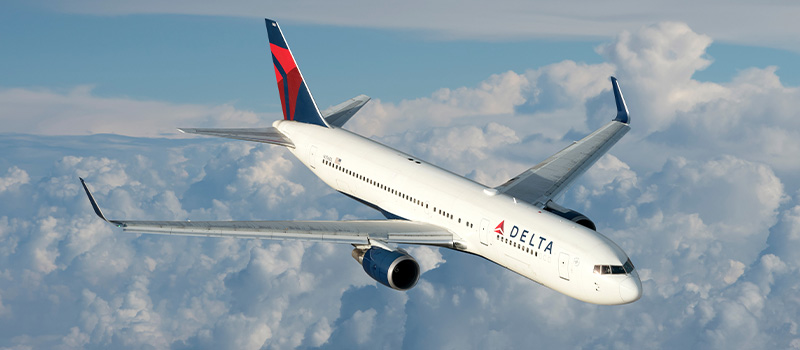 Delta airplane flying above clouds