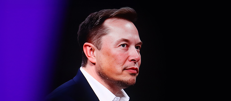 Elon Musk in suit looking forward