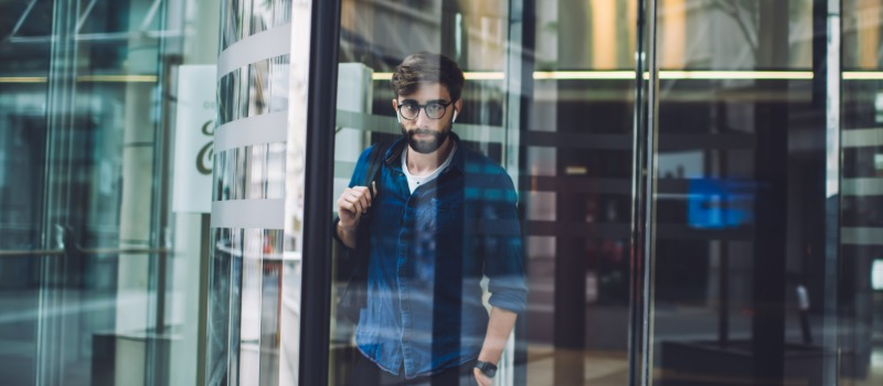 Man exiting modern revolving door