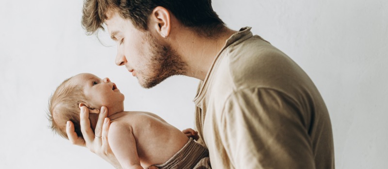 Father holding newborn baby lovingly