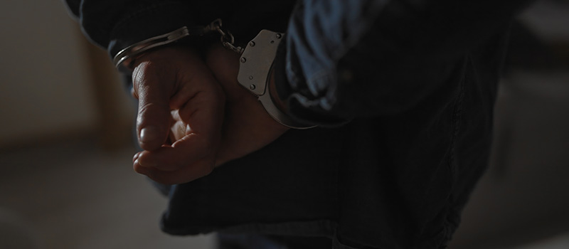Hands in handcuffs, arrested person