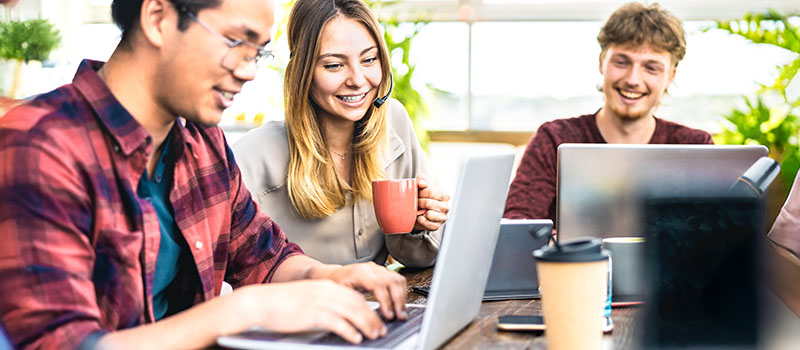 Young professionals collaborating with laptops