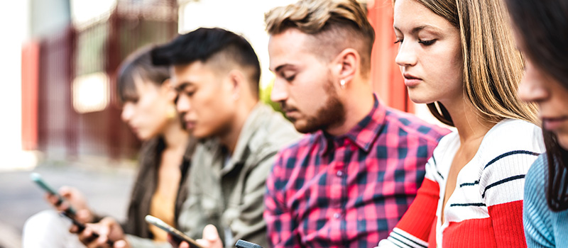 Young people using smartphones outdoors