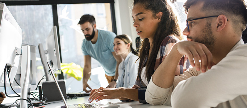 Gen Z professionals collaborating at computers
