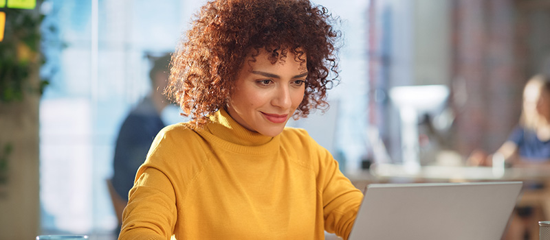 Woman working on laptop smiling
