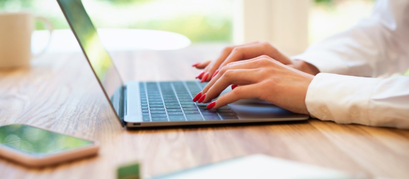 Woman typing on laptop keyboard