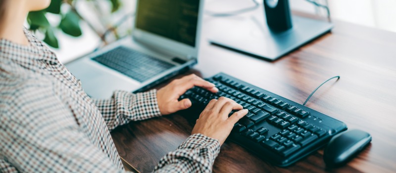 Person typing on computer keyboard