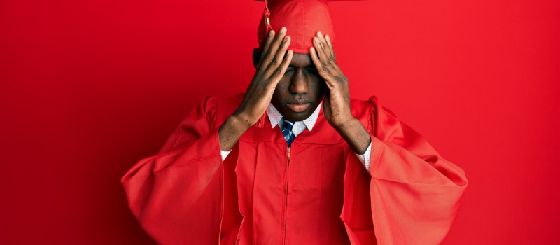Stressed graduate in red gown