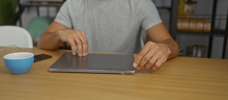 Person closing laptop at desk