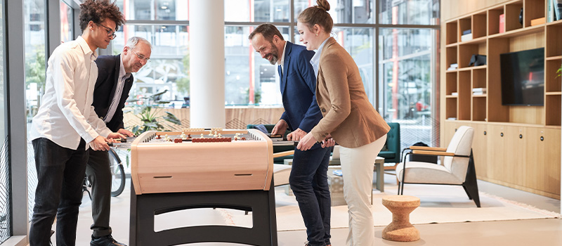 Office workers playing foosball game