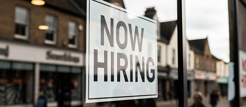 Now hiring sign on window