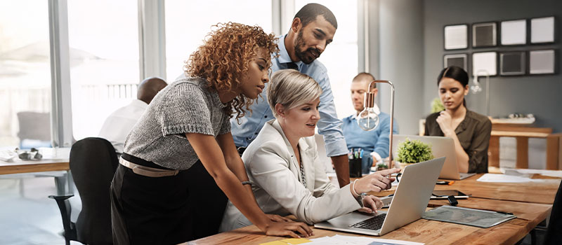 Business team collaborating at laptop
