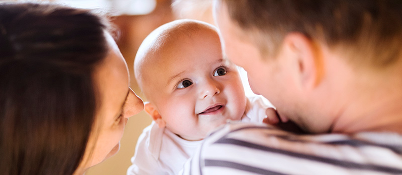Smiling baby with parents cuddling