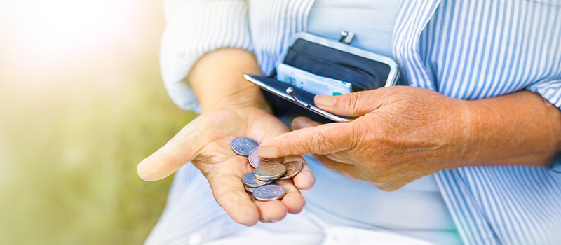 Senior counting coins, open wallet