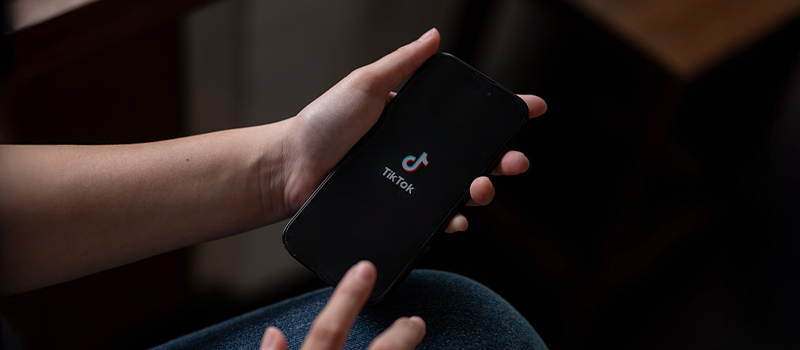 Person holding phone with TikTok