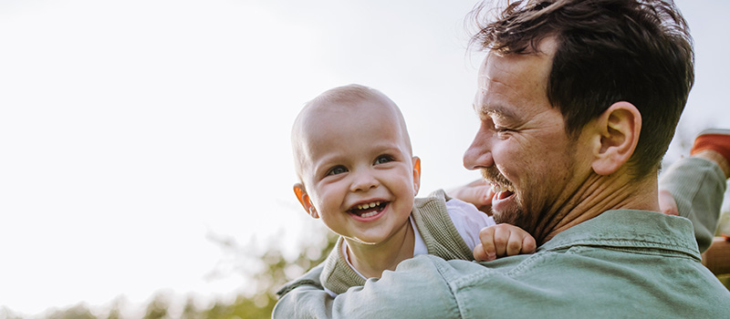 Smiling father holding happy baby