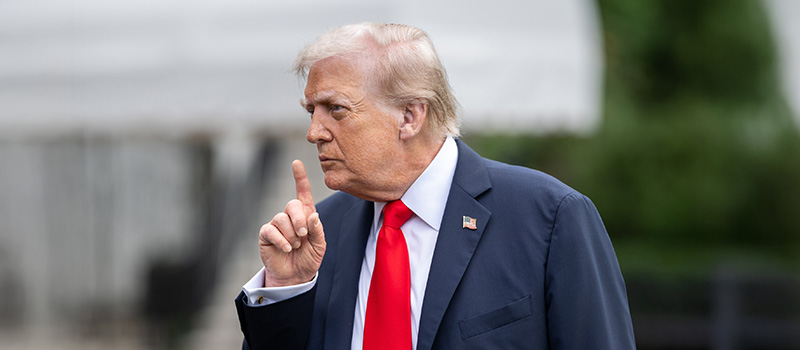 Donald Trump in suit raising finger