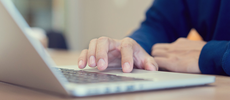 Person typing on laptop keyboard