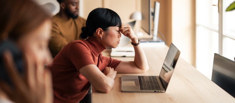 Stressed woman working at laptop