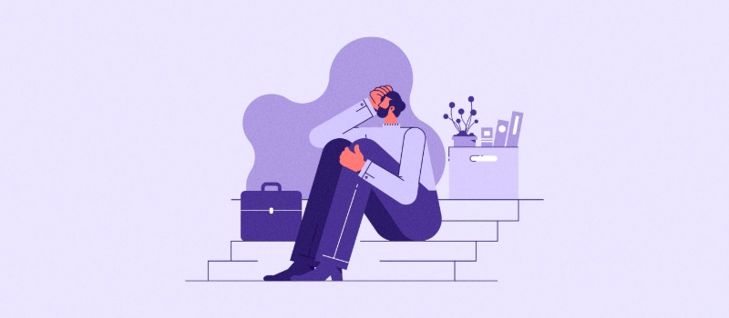 Stressed worker sitting with box