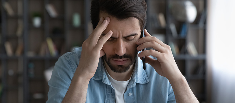 Stressed man phone call headache