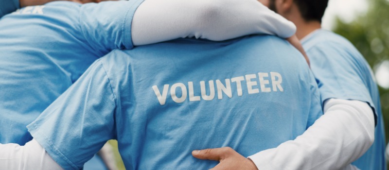 Group of volunteers hugging outdoors