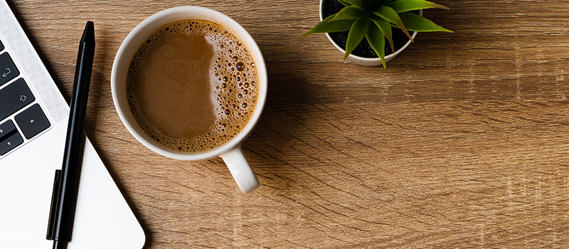 Coffee, laptop, pen, plant, desk