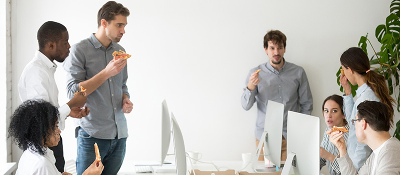 Office team eating pizza together
