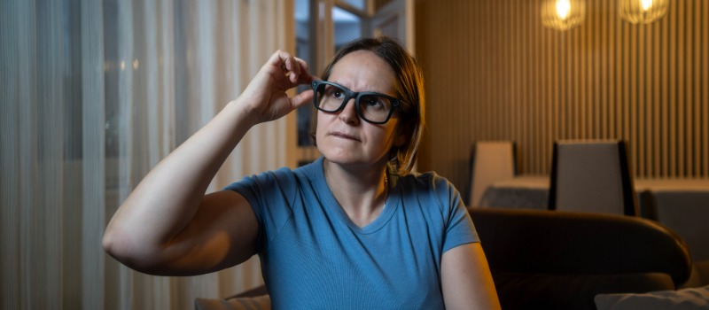 Smart glasses - the workplace privacy & data risks of the new wearable tech fad Woman adjusting glasses indoors evening