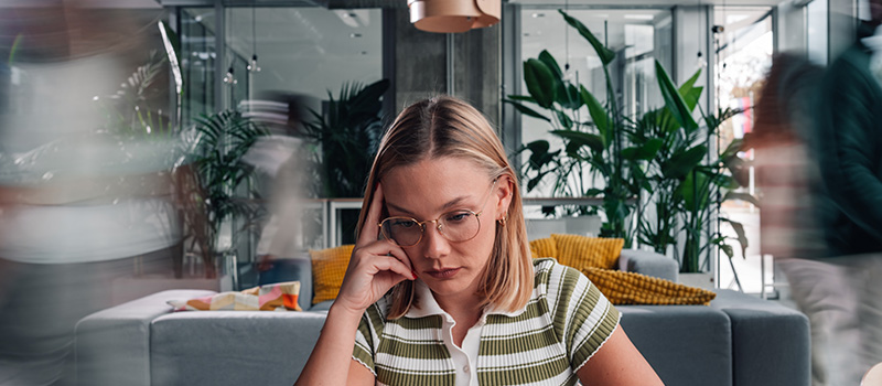 Stressed woman in busy office