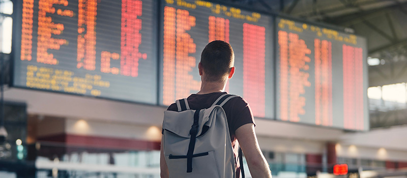 Traveler checking airport departure board