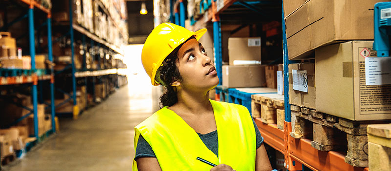 Warehouse worker inspecting inventory shelves