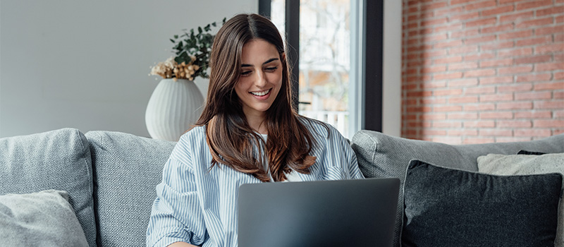 Woman working on laptop couch