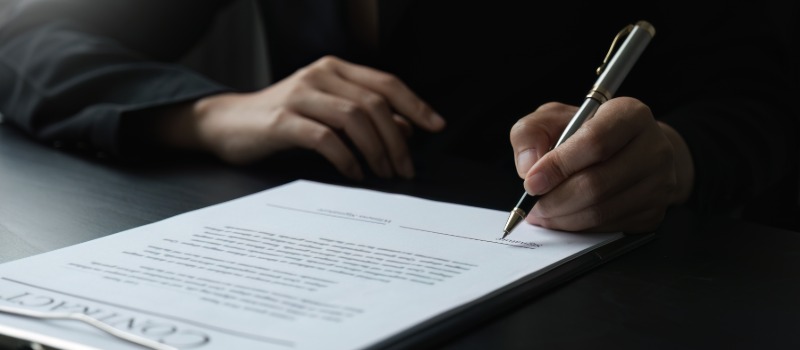 Signing business contract with pen